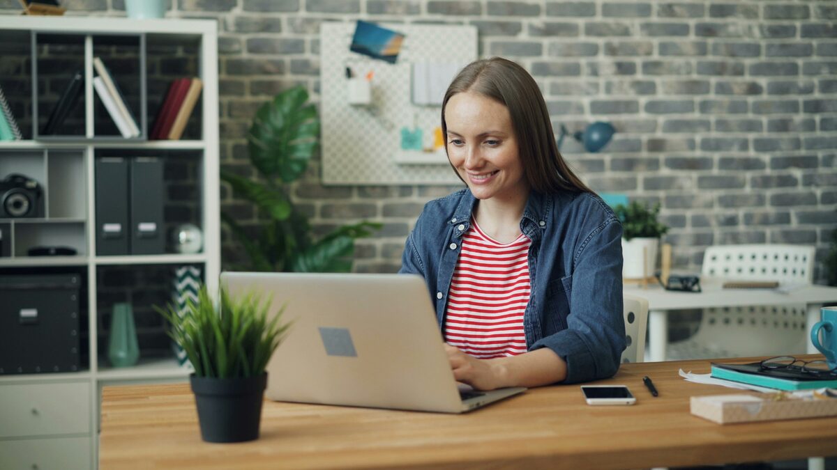 Angajată de birou care lucrează pe laptop cu XLOOKUP și VLOOKUP într-un tabel Excel cu prețuri