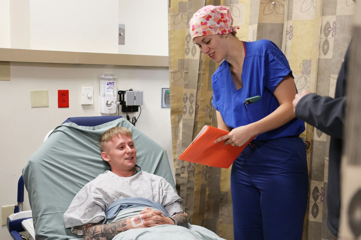 Asistentă medicală cu un dosar în mână care prezintă materialele informative pentru pacienți