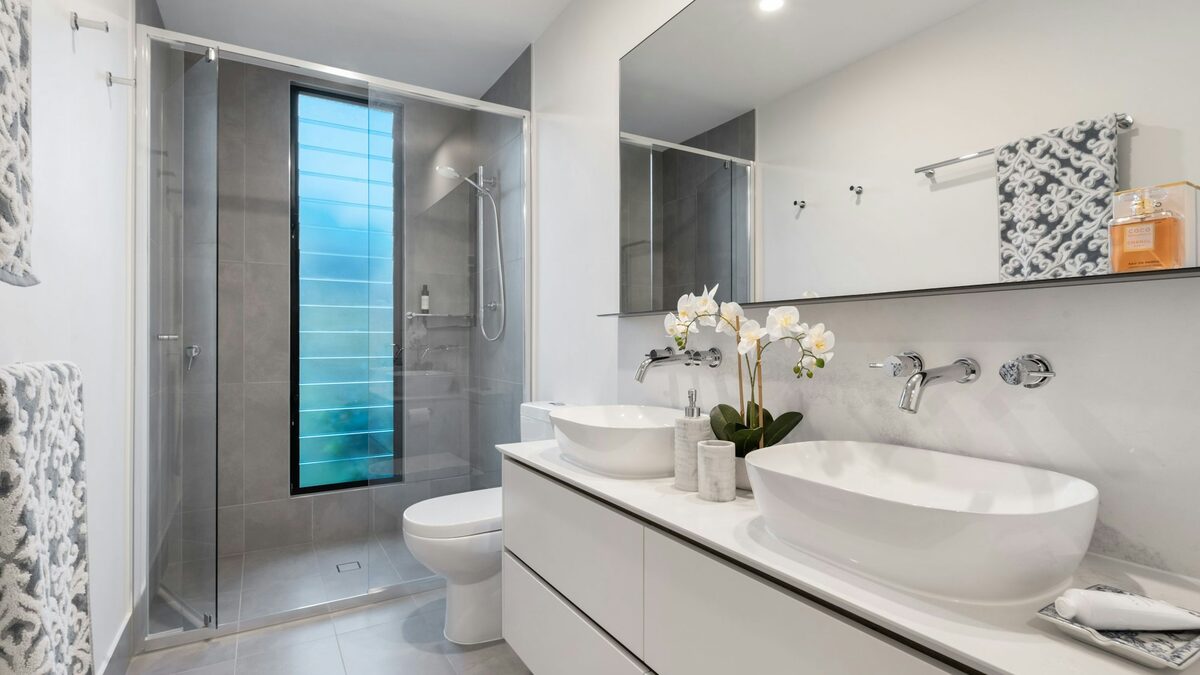 Baie renovată, cu duș și lavoar noi, fotografiată pentru pozele de la lucrări înainte și după