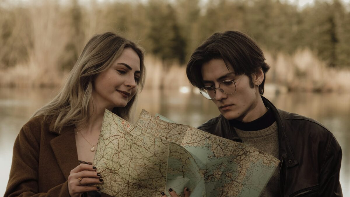 Cuplu care studiază împreună o hartă, pregătind planificarea vacanței cu AI