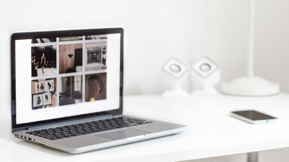 Laptop pe un birou alb, cu un site de prezentare deschis, ca atunci când verifici lucrările unui furnizor