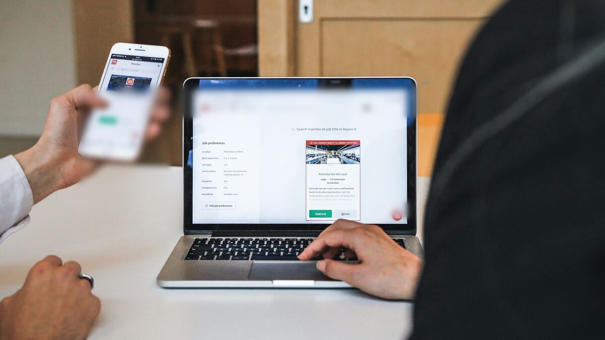 Client care își verifică documentele în zona privată pentru clienți, pe laptop și pe telefon