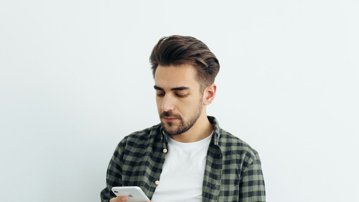 Tânăr care vede pe telefon reclamele personalizate cu pantofii la care s-a uitat ieri într-un magazin online