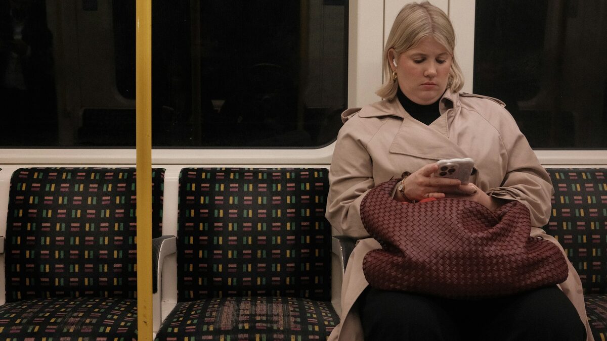 Femeie în metrou care folosește ChatGPT pe telefon