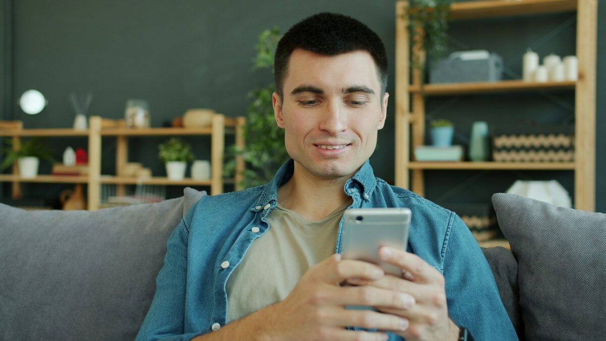 Bărbat care schimbă limba în care răspunde ChatGPT din setările aplicației de pe telefon