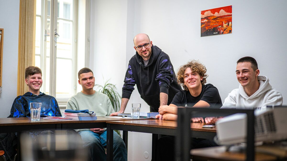 Profesor alături de elevii lui în clasă, discutând cu ei despre folosirea AI la școală