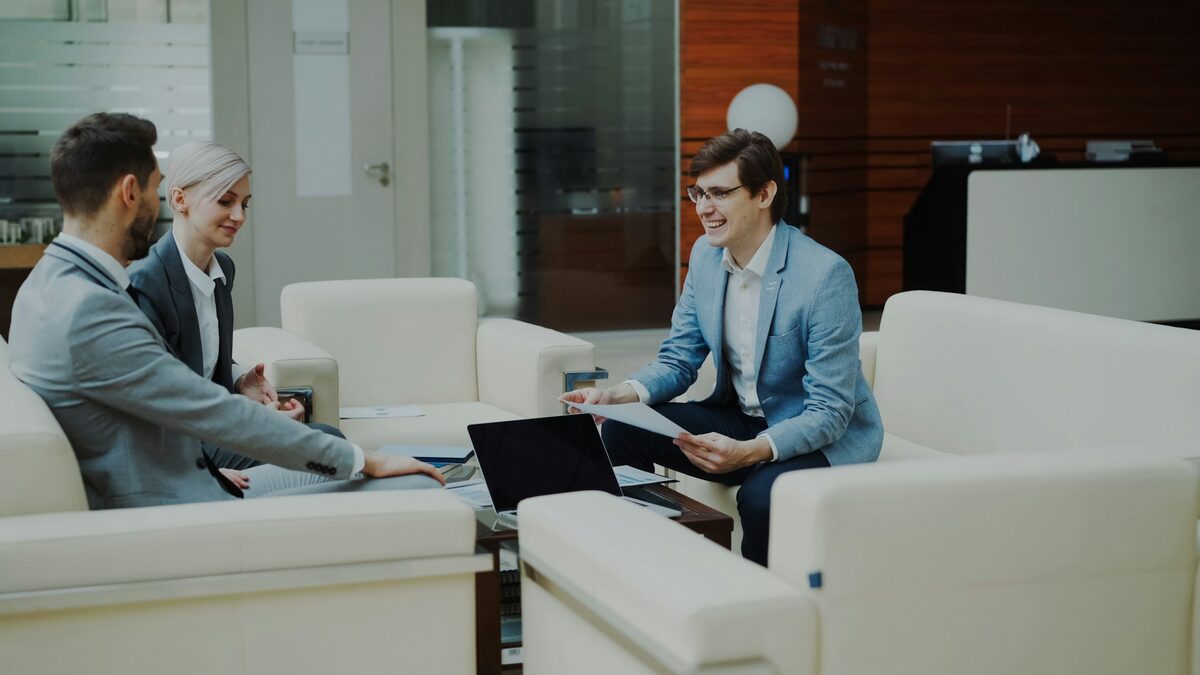 Trei colegi care discută la laptop cât costă un chatbot pentru site-ul firmei