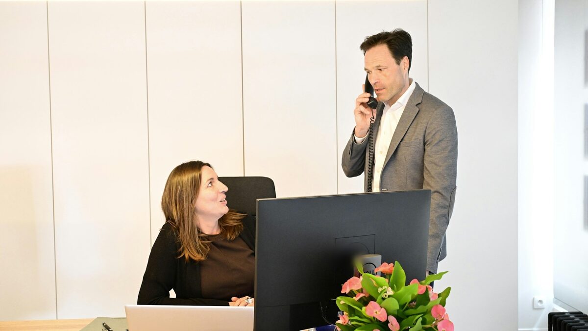 Coleg care vorbește la telefonul fix al biroului, apeluri pe care le poate prelua un robot telefonic, în funcție de cât costă