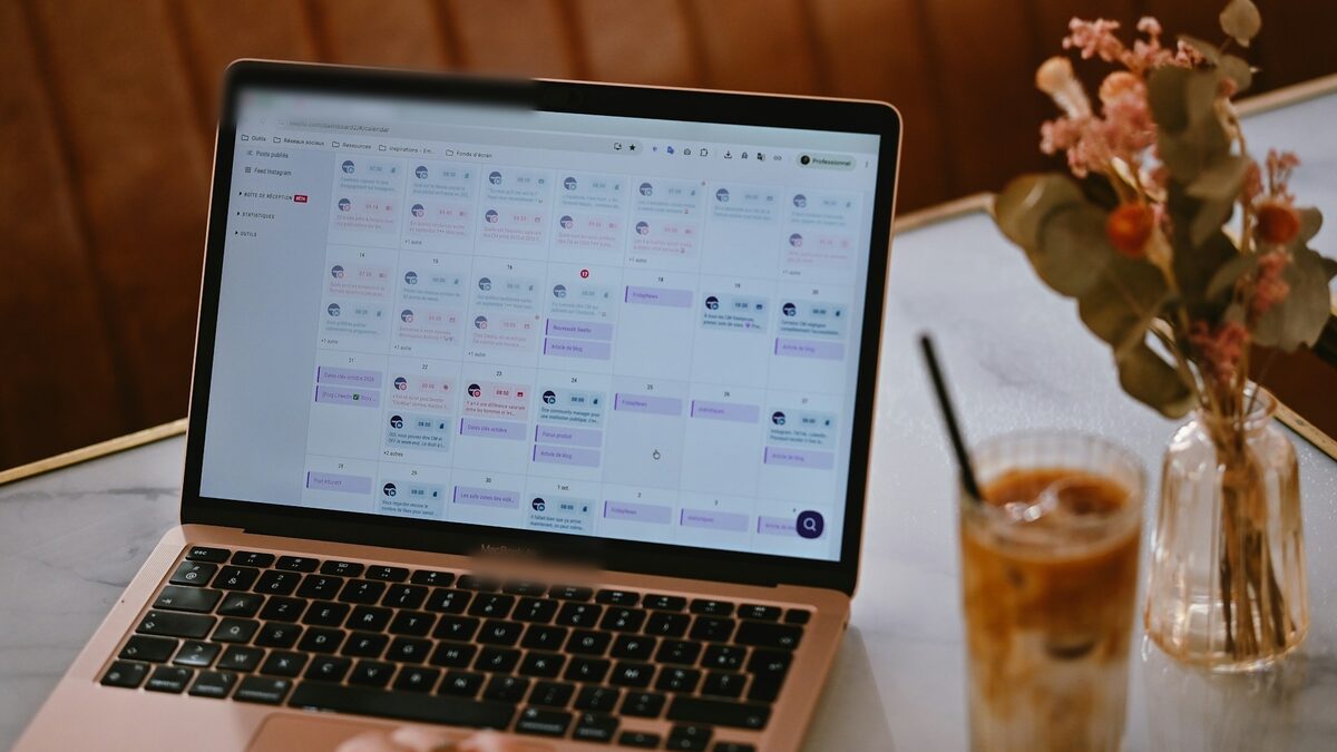 Laptop cu un calendar de programări pe o masă de cafenea, ca exemplu pentru cât costă un site cu programări online