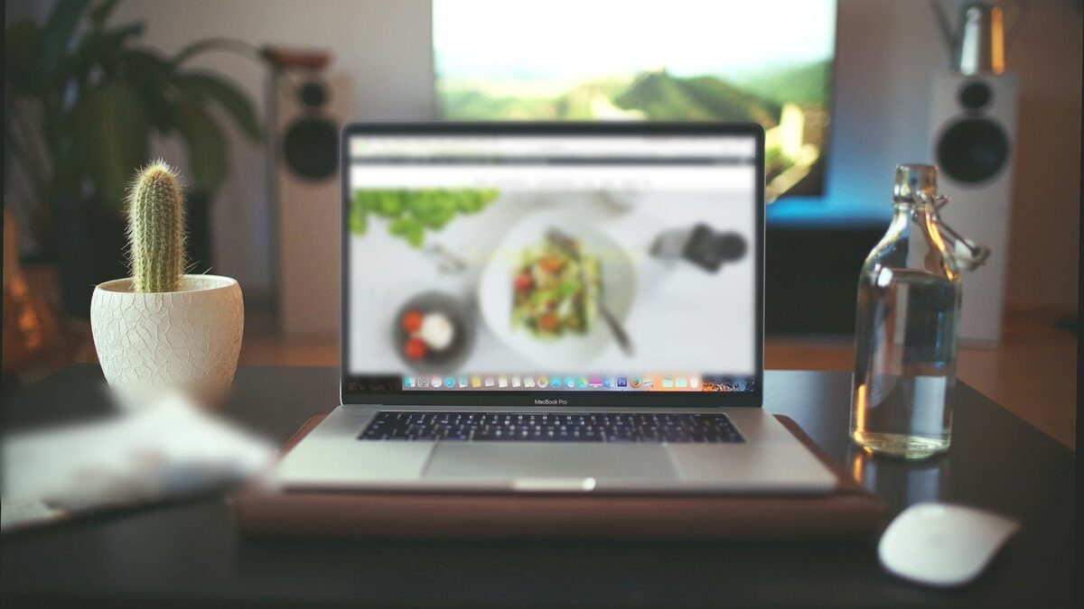 Laptop pe birou cu un site de prezentare deschis, pentru calculul cât costă un site de prezentare