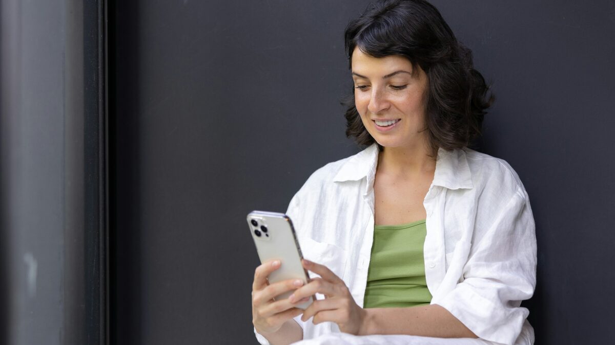 Femeie care verifică pe telefon urmărirea coletului, cu numărul AWB primit de la magazin