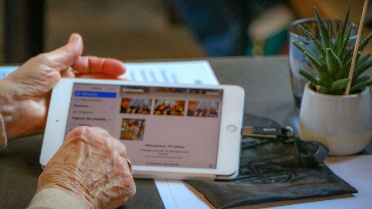 Mâinile unei doamne în vârstă pe o tabletă, în timp ce învață căutarea pe internet pentru seniori