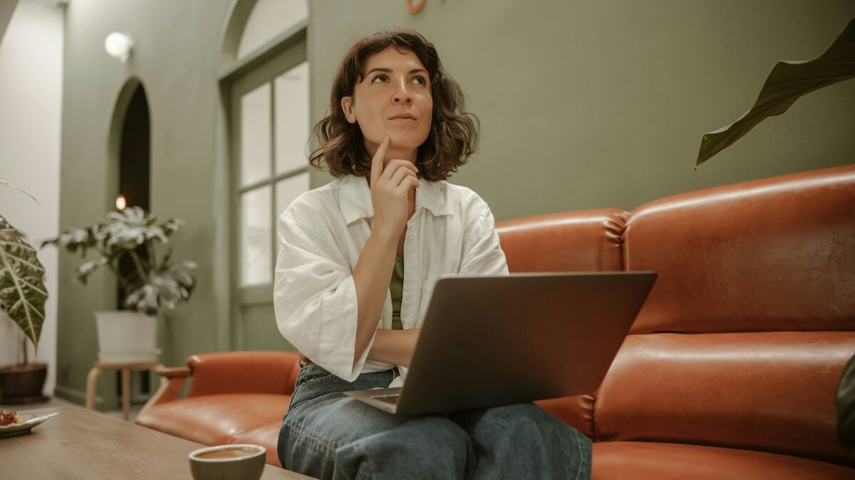 Femeie care citește pe laptop un răspuns AI și se întreabă dacă AI-ul e mereu obiectiv