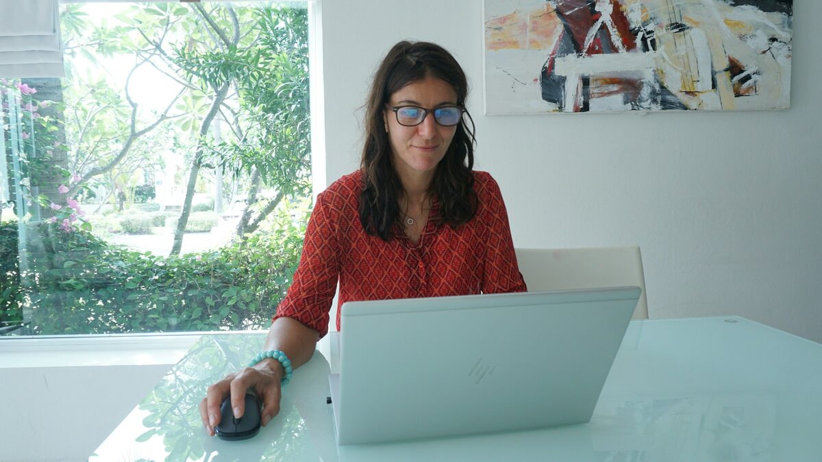 Femeie la birou care verifică pe laptop setările de confidențialitate Facebook
