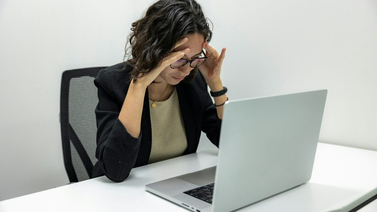 Femeie îngrijorată în fața unui laptop lent, care verifică de ce calculatorul merge greu