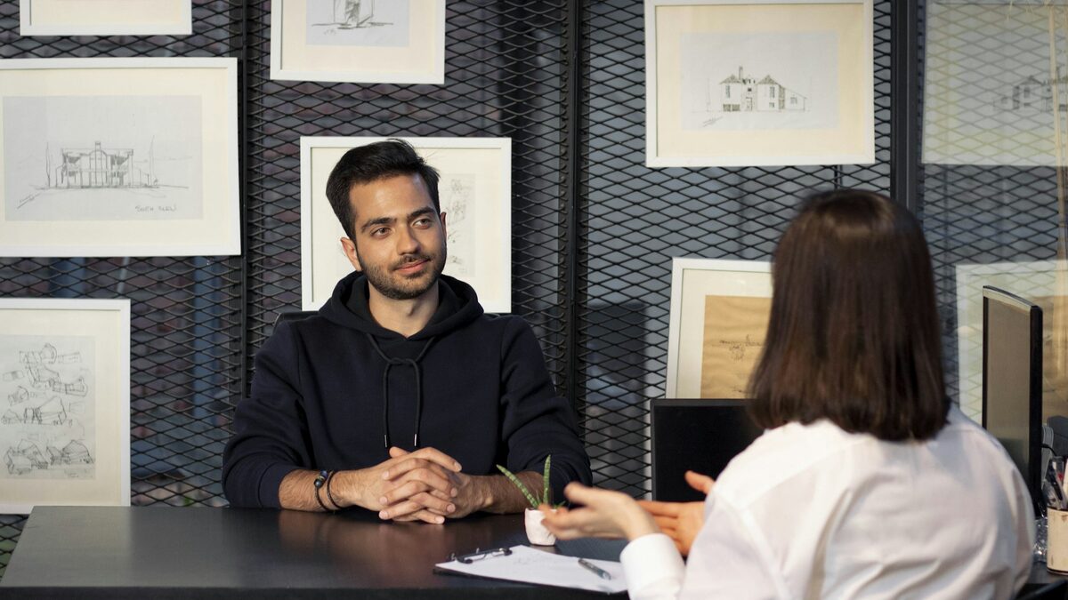 Angajatoare care discută cu un candidat la un interviu, venit după un anunț de angajare scris cu AI